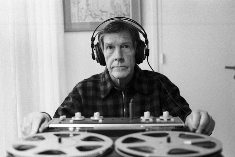John Cage wearing headphones at a tape machine